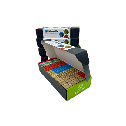 Åpen eske med Klikkodilla magnetiske byggeklosser som viser innholdet i startpakken, inkludert blokker med mønster av gress, tre, stein og vann.